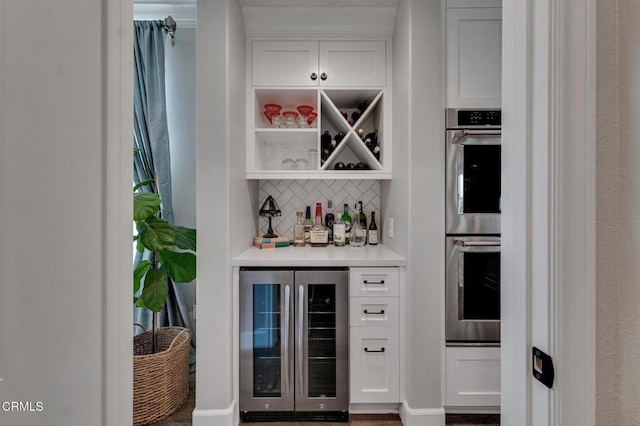 20752 Veneto Way, Porter Ranch, CA 91326 - indoor dry bar featuring wine cooler, double oven, backsplash, and wood finished floors