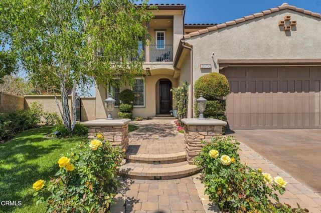 20752 Veneto Way, Porter Ranch, CA 91326 - view of front facade featuring stucco siding, a balcony, driveway, a garage, and a tiled roof