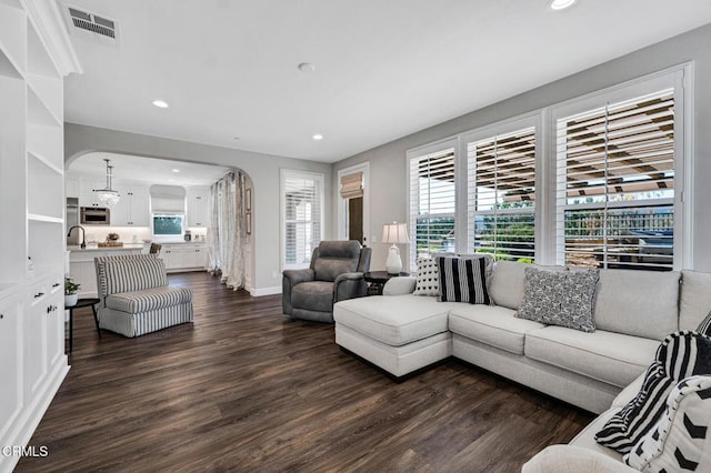 20752 Veneto Way, Porter Ranch, CA 91326 - living area with arched walkways, dark wood-type flooring, recessed lighting, and healthy amount of natural light