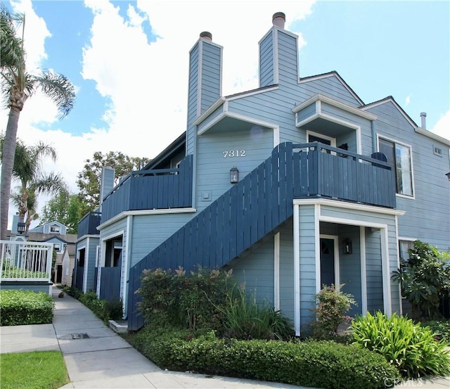 7312 Quill Dr Unit 13, Downey, CA 90242 - view of front of home with a chimney and a balcony