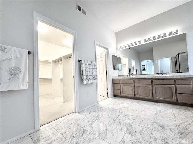 3025 Camino De Las Piedras, El Cajon, CA 92019 - full bath with double vanity, a walk in closet, a shower stall, and marble finish flooring