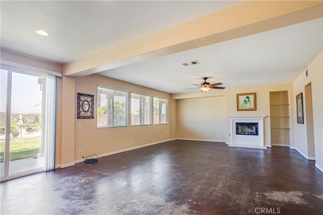 22939 Montanya Pl, Murrieta, CA 92562 - unfurnished living room with concrete floors, a glass covered fireplace, built in features, baseboards, and a textured ceiling
