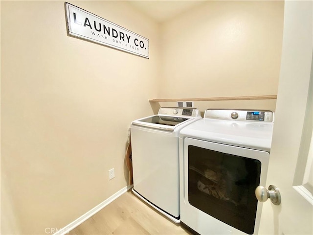 clothes washing area with baseboards, laundry area, and washer and clothes dryer