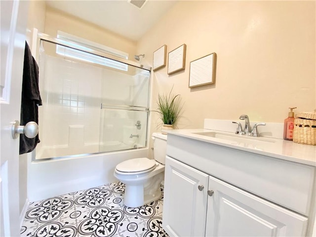 full bathroom with enclosed tub / shower combo, toilet, and vanity