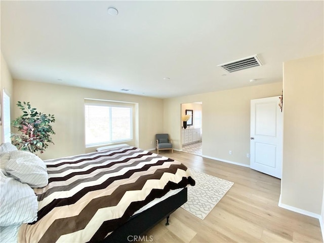 bedroom with baseboards, visible vents, light wood-type flooring, and multiple windows