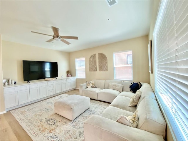 living area with visible vents, ceiling fan, and light wood-style flooring