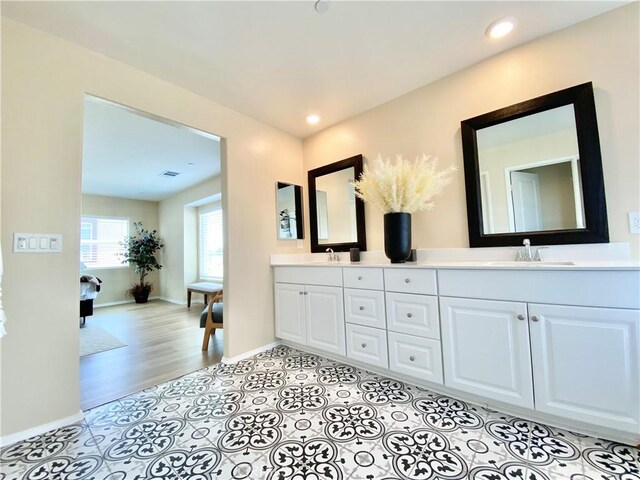 full bathroom featuring recessed lighting, double vanity, a sink, and baseboards