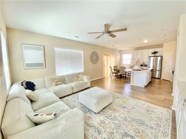 living room featuring recessed lighting, light wood-style floors, baseboards, visible vents, and a ceiling fan
