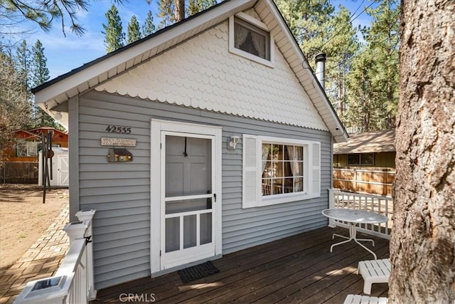 exterior space featuring an outdoor structure, a deck, and a shed