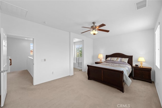 bedroom with visible vents, a ceiling fan, baseboards, and light carpet