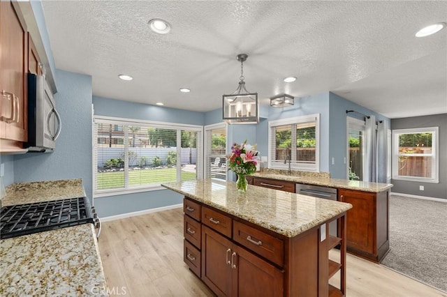 9334 Shamouti Dr, Riverside, CA 92508 - kitchen with a kitchen island, a textured ceiling, baseboards, appliances with stainless steel finishes, and a sink