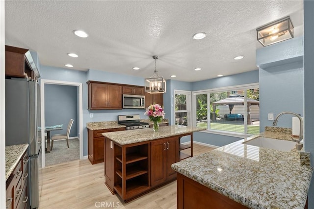 9334 Shamouti Dr, Riverside, CA 92508 - kitchen with appliances with stainless steel finishes, a sink, open shelves, a textured ceiling, and light wood-style floors