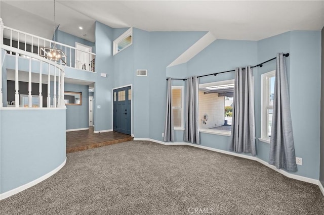 9334 Shamouti Dr, Riverside, CA 92508 - unfurnished living room featuring carpet floors, baseboards, high vaulted ceiling, and a chandelier