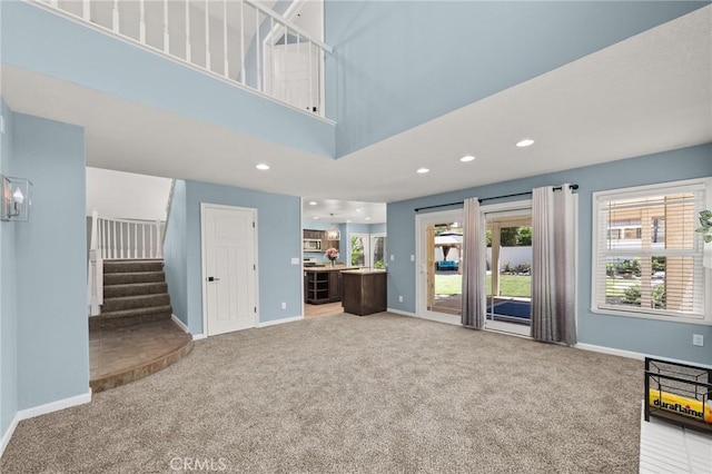 9334 Shamouti Dr, Riverside, CA 92508 - unfurnished living room featuring carpet flooring, baseboards, stairway, recessed lighting, and a high ceiling