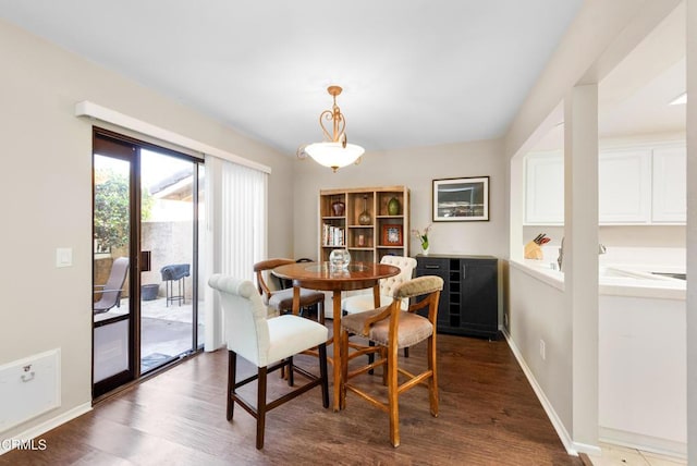 dining area with dark wood-style flooring and baseboards