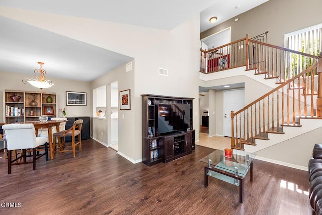 living area with visible vents, stairway, wood finished floors, and baseboards