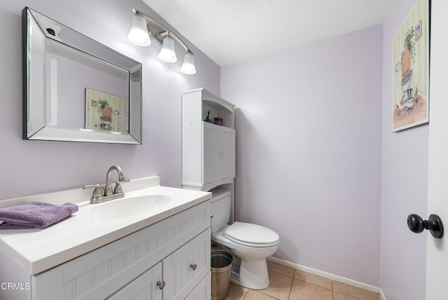half bath featuring toilet, tile patterned flooring, vanity, and baseboards