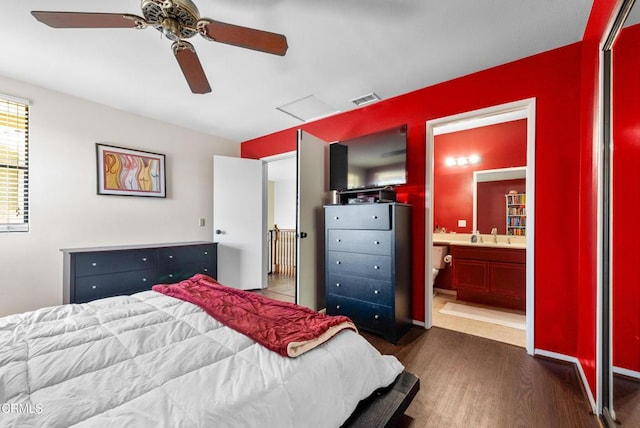 bedroom with visible vents, ceiling fan, connected bathroom, and dark wood-type flooring