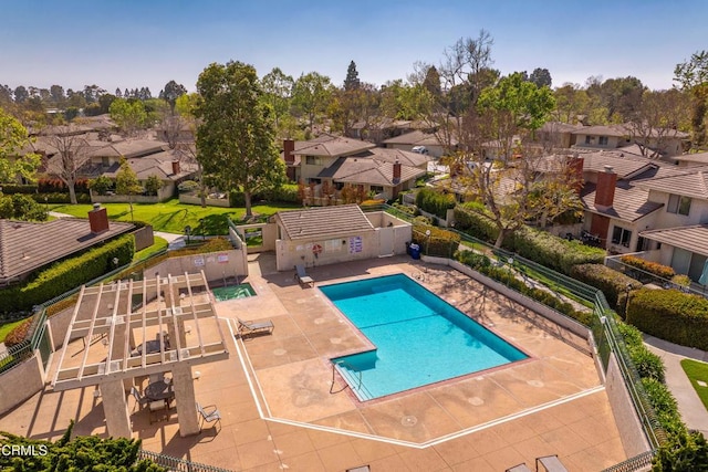 community pool featuring a residential view, fence, and a patio area