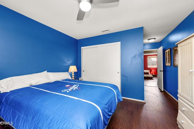 bedroom with wood finished floors, a closet, baseboards, visible vents, and a ceiling fan