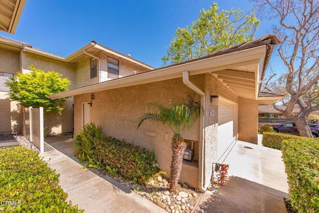 view of side of property featuring a garage and stucco siding