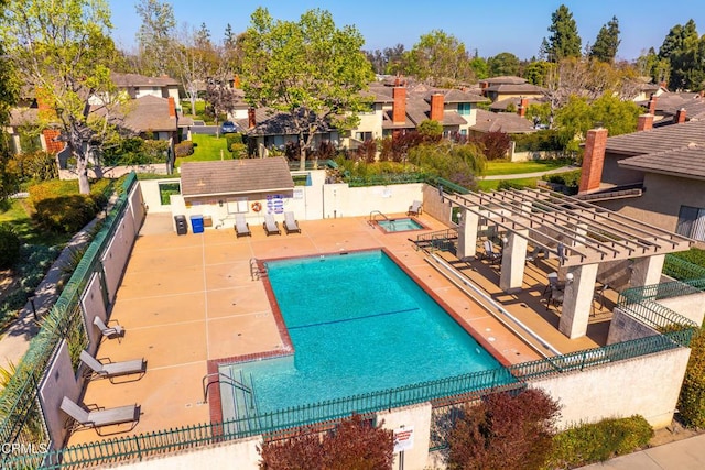 community pool with a residential view, a pergola, and fence