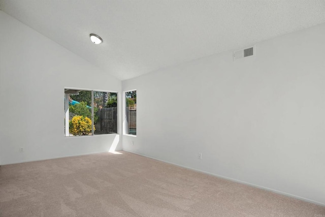 carpeted spare room featuring a towering ceiling, visible vents, and baseboards