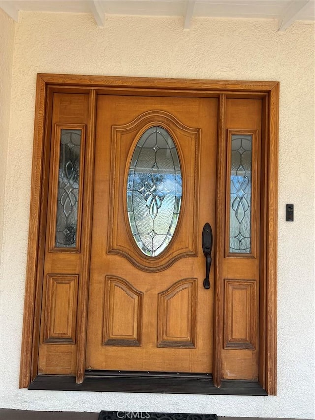 entrance to property featuring stucco siding