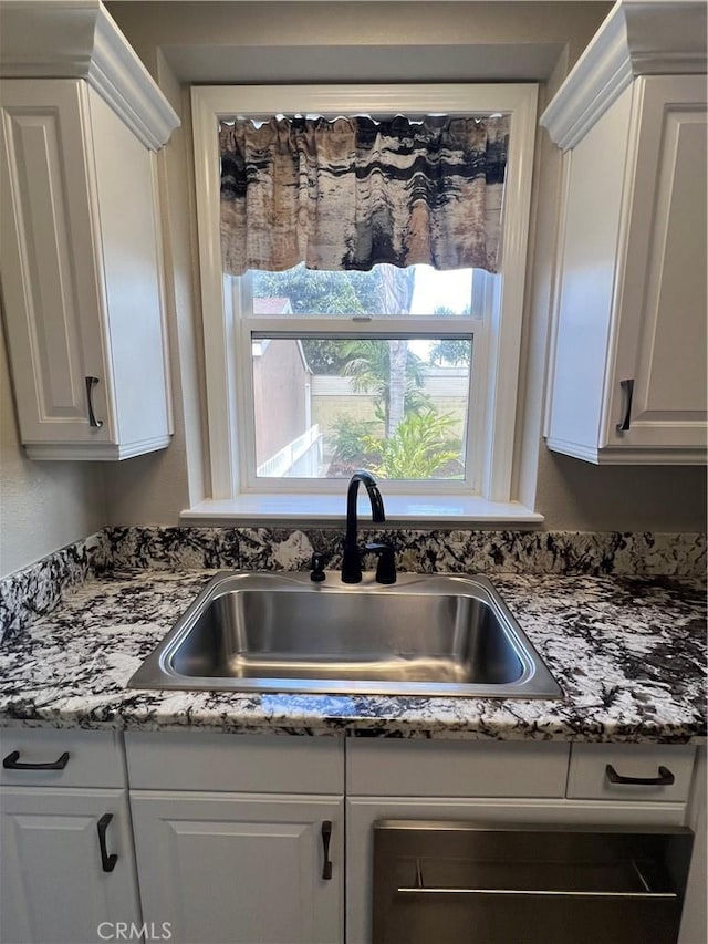 kitchen with white cabinetry and a sink