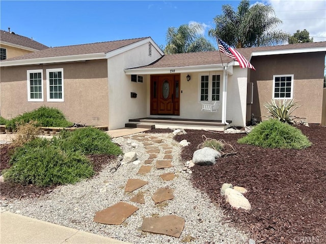 ranch-style house with stucco siding and covered porch