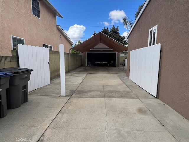 exterior space with a detached garage, fence, and an outdoor structure