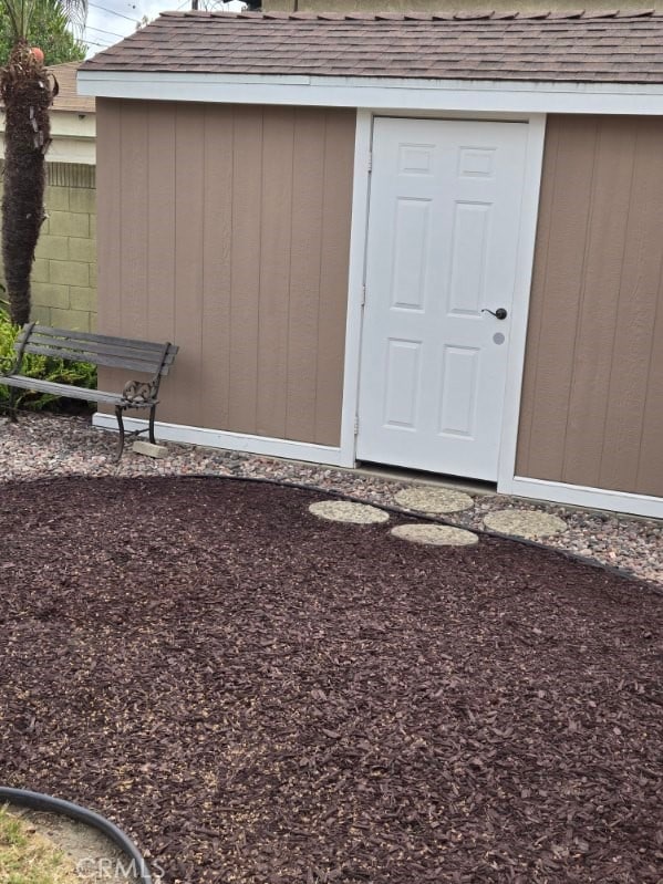 entrance to property featuring roof with shingles