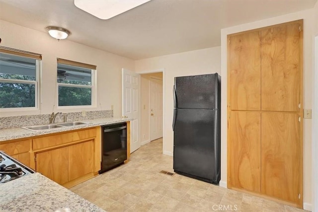 kitchen with black appliances, a sink, and light countertops