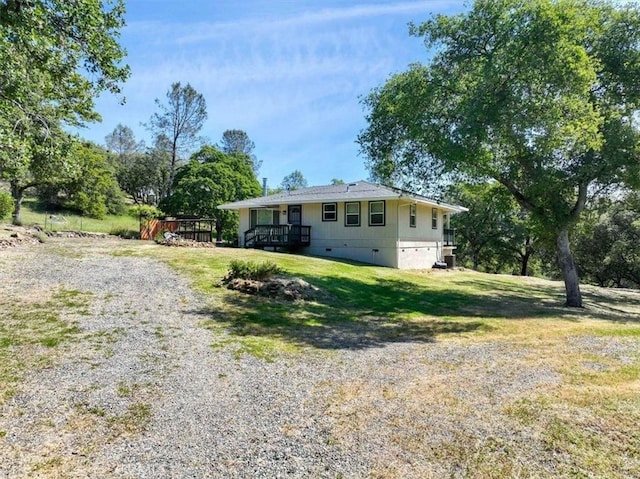 rear view of house featuring a yard and a wooden deck