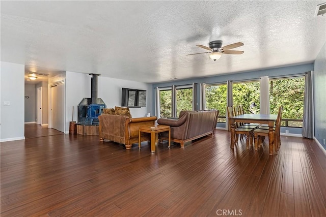 9553 Durango Rd, Atascadero, CA 93422 - living room with a wood stove, a ceiling fan, dark wood-style floors, a textured ceiling, and baseboards