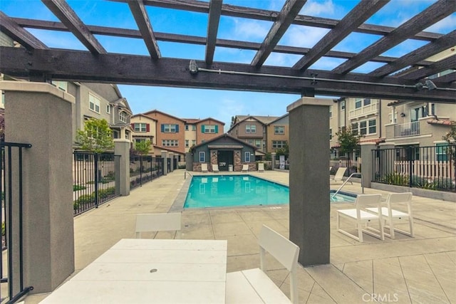 pool with fence, a patio area, a residential view, and a pergola