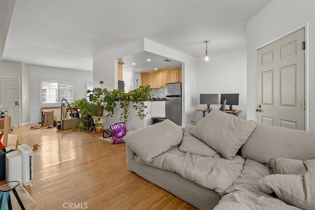 living area with recessed lighting, light wood-style flooring, and baseboards