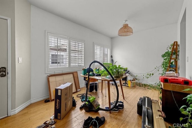 workout room featuring light wood-style floors and baseboards