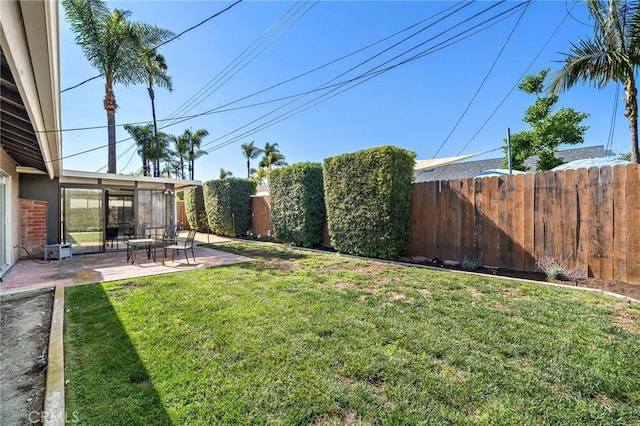view of yard with a fenced backyard, a sunroom, and a patio area