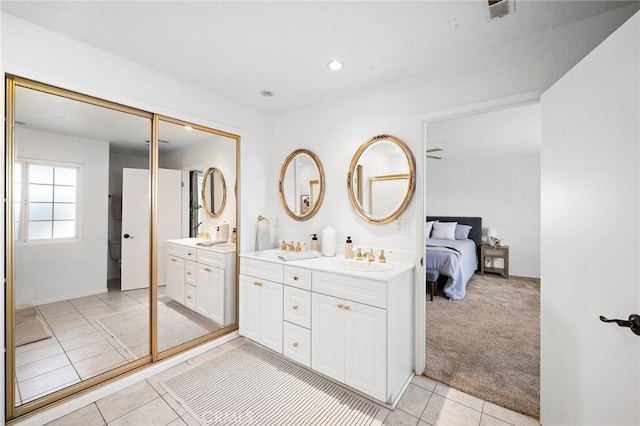 ensuite bathroom featuring tile patterned flooring, double vanity, visible vents, ensuite bathroom, and a sink