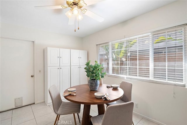 dining space featuring baseboards, a ceiling fan, and light tile patterned floors