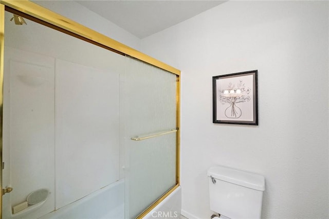 bathroom featuring bath / shower combo with glass door and toilet