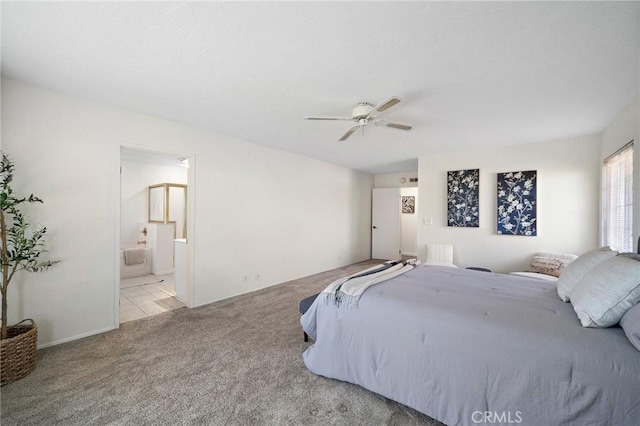 carpeted bedroom featuring a ceiling fan and ensuite bath