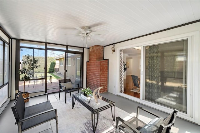 sunroom / solarium featuring expansive windows, a ceiling fan, and an outdoor hangout area
