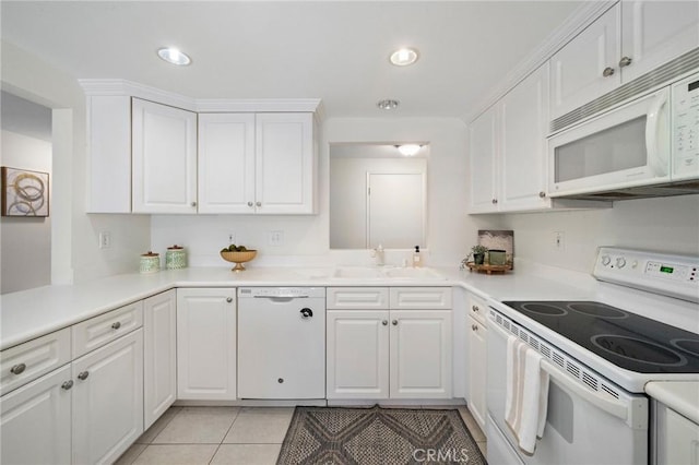 kitchen with a sink, white cabinetry, and white appliances