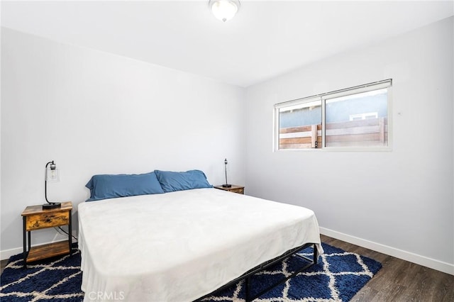 bedroom featuring dark wood-type flooring and baseboards