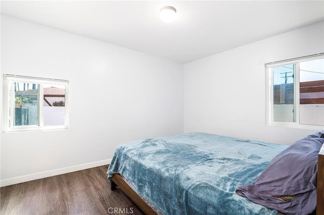 bedroom with wood finished floors and baseboards