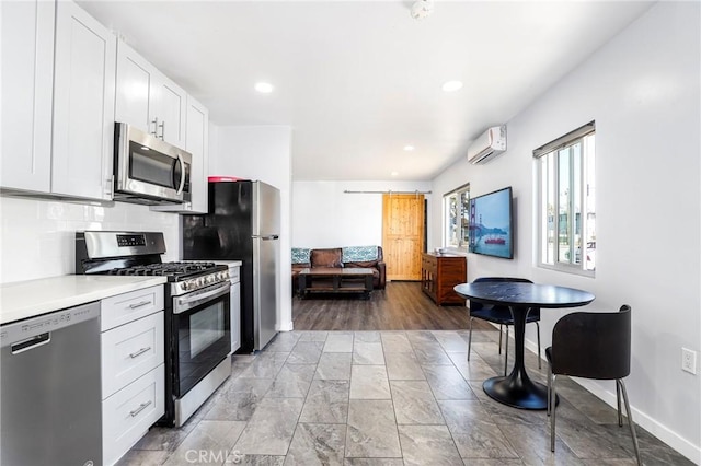kitchen featuring white cabinetry, stainless steel appliances, light countertops, an AC wall unit, and backsplash