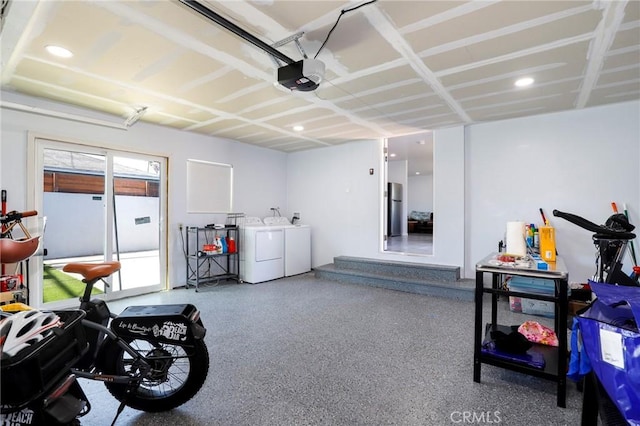 garage with recessed lighting, washing machine and clothes dryer, and a garage door opener