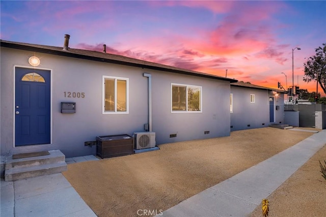 view of front of home featuring a patio area, stucco siding, ac unit, and crawl space